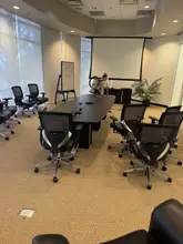 Daltex crew member vacuuming a Dallas-Fort Worth conference room with a backpack vacuum