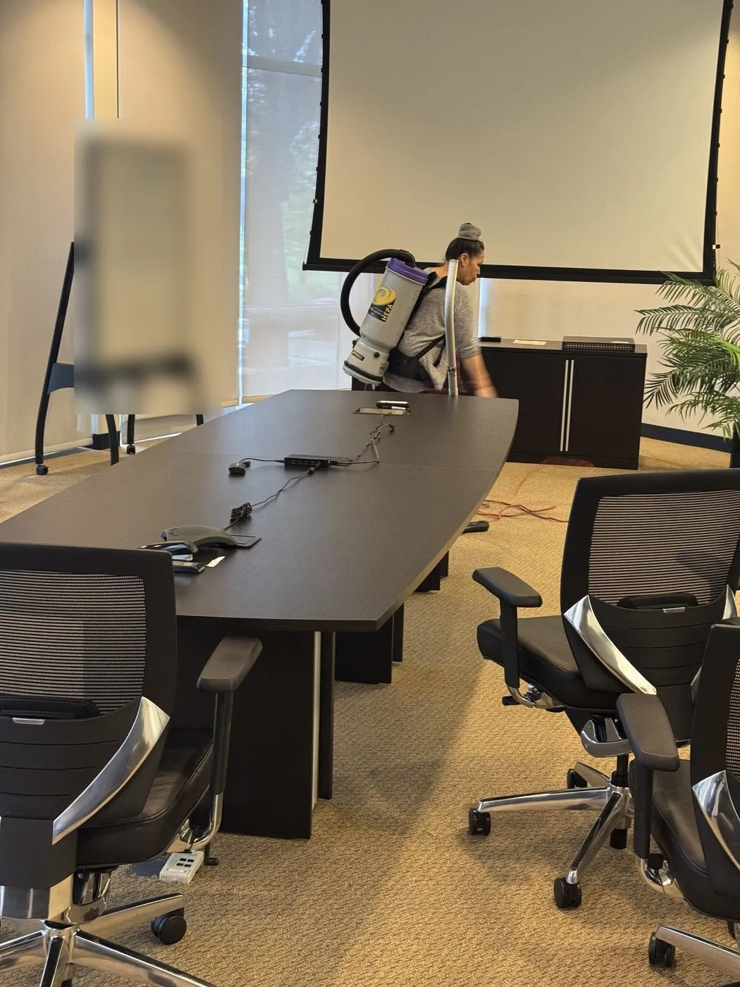 Crew member vacuuming a Dallas-Fort Worth conference room after business hours