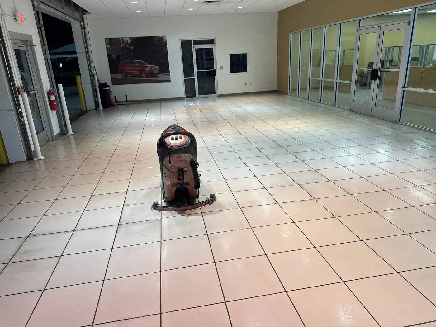 Walk-behind floor scrubber cleaning a large tile showroom floor at a Dallas-Fort Worth commercial property