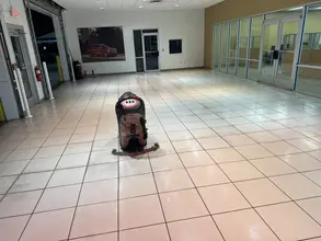 Walk-behind floor scrubber cleaning a large tile showroom floor at a Dallas-Fort Worth commercial property