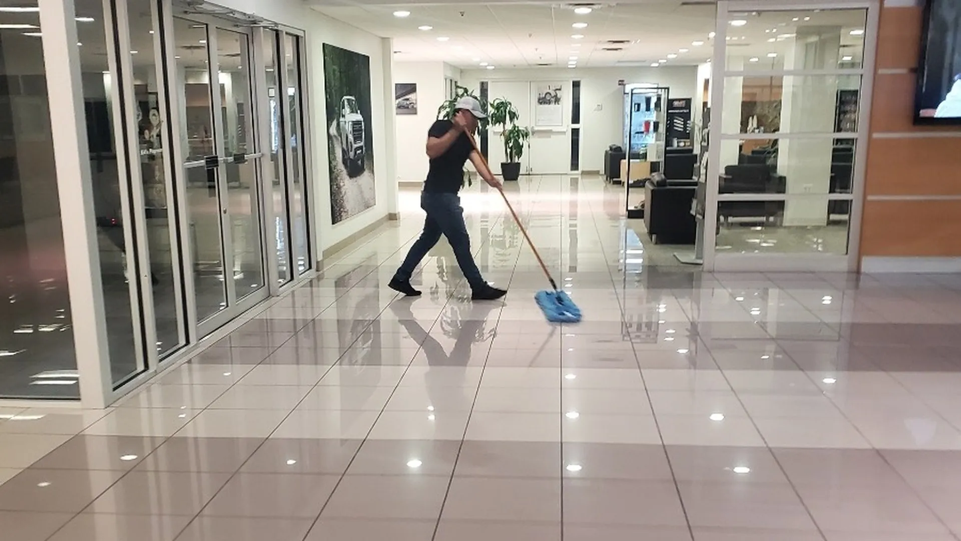 Daltex crew member mopping a polished tile corridor in a Dallas-Fort Worth commercial building
