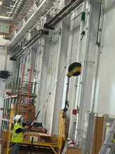 Daltex crew member high dusting overhead pipes and fixtures in a Dallas-Fort Worth industrial facility