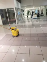 Mop bucket in a Dallas-Fort Worth commercial corridor with freshly cleaned tile floors