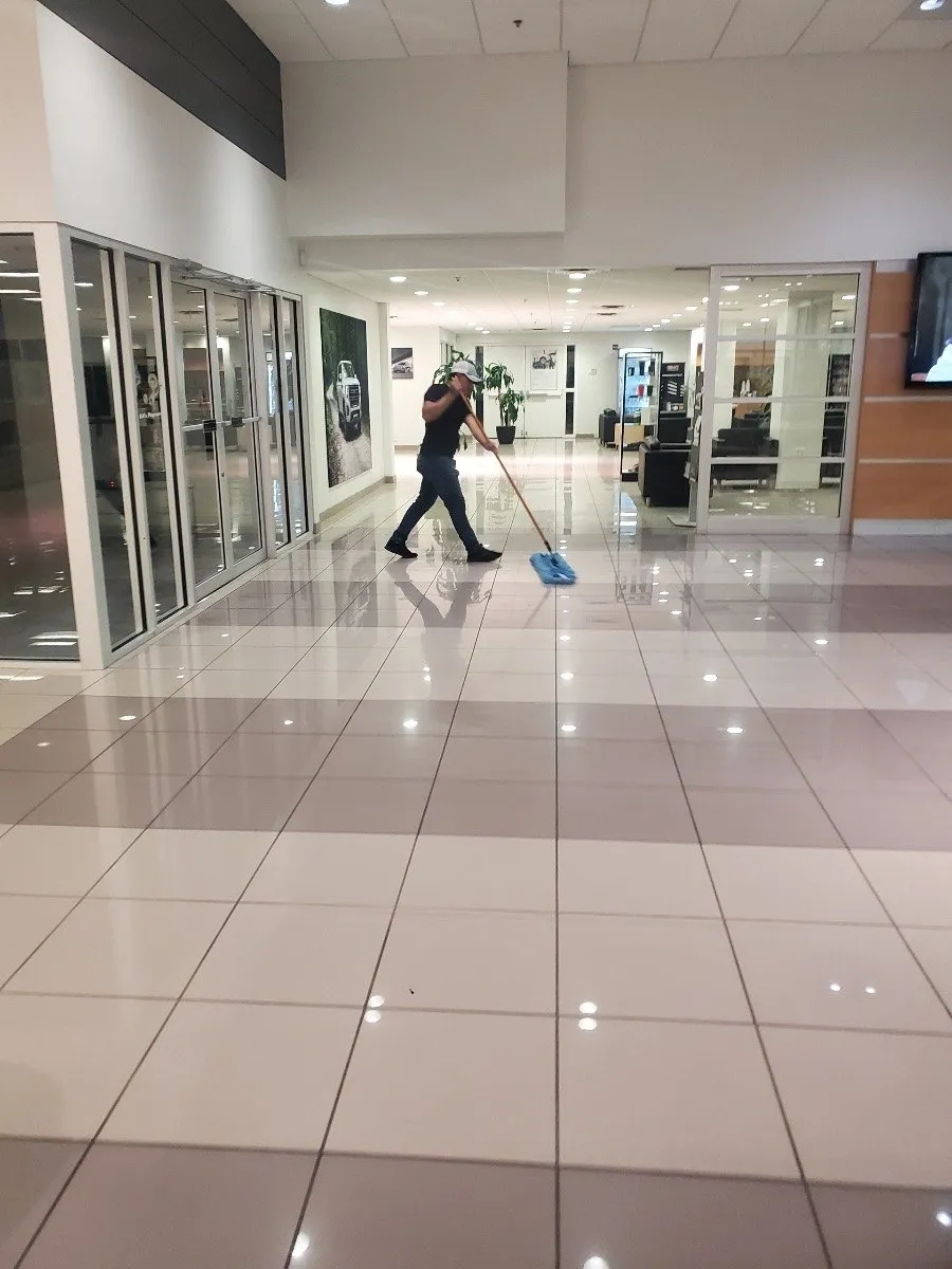 Daltex crew member mopping a polished tile corridor in a Dallas-Fort Worth commercial building