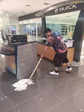Daltex crew member mopping a dealership showroom floor in Dallas-Fort Worth