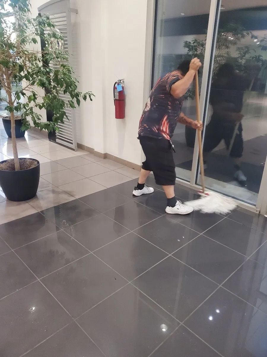 Crew member mopping a glossy entrance floor at a Dallas-Fort Worth commercial building