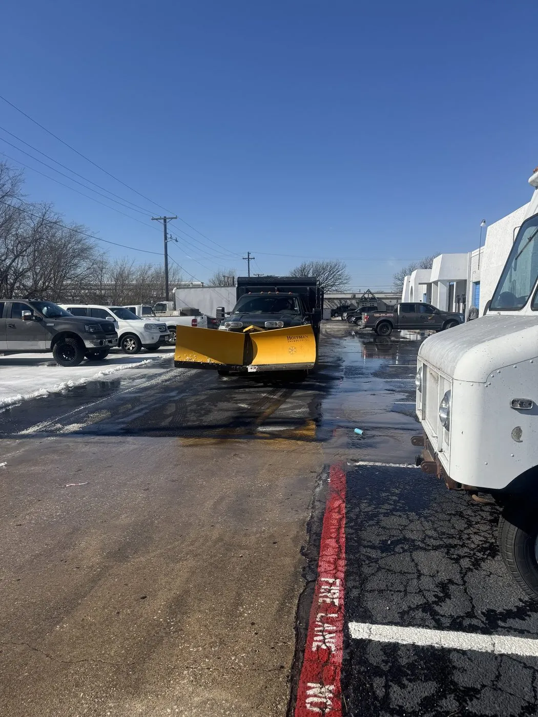 Spreader truck treating a Dallas-Fort Worth commercial parking lot in winter conditions