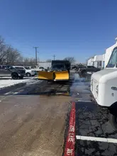 Spreader truck treating a Dallas-Fort Worth commercial parking lot in winter conditions