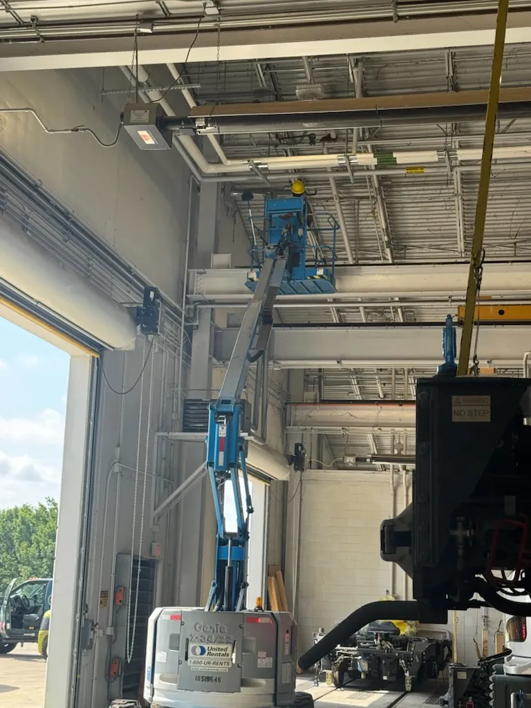 Boom lift raised for high ceiling cleaning inside a Dallas-Fort Worth commercial shop bay